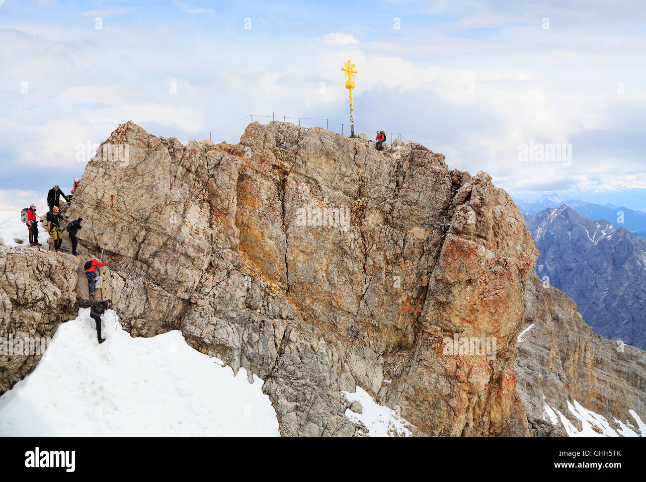 Climbers at the cross on the summit of Zugspitze Mountain, the highest in Germany. Stock Photo