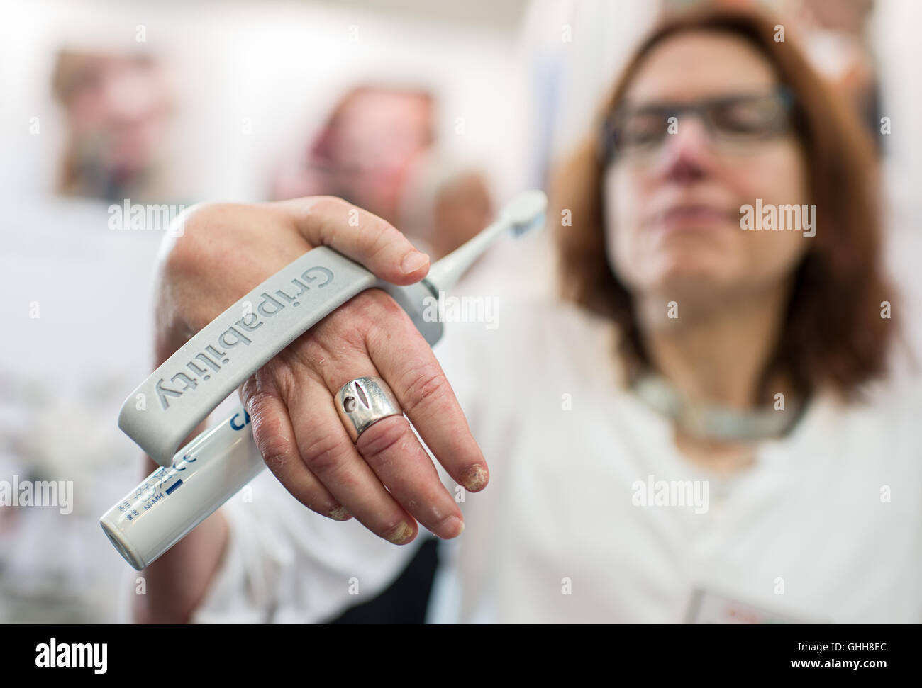Duesseldorf, Germany. 28th Sep, 2016. A woman holding up a so-called 't.brush' during the opening of the international care fair 'Rheacare' in Duesseldorf, Germany, 28 September 2016. The 't.brush' is a handle for electrical toothbrushes. The fair runs until 1 October 2016. PHOTO: WOLFRAM KASTL/dpa/Alamy Live News Stock Photo