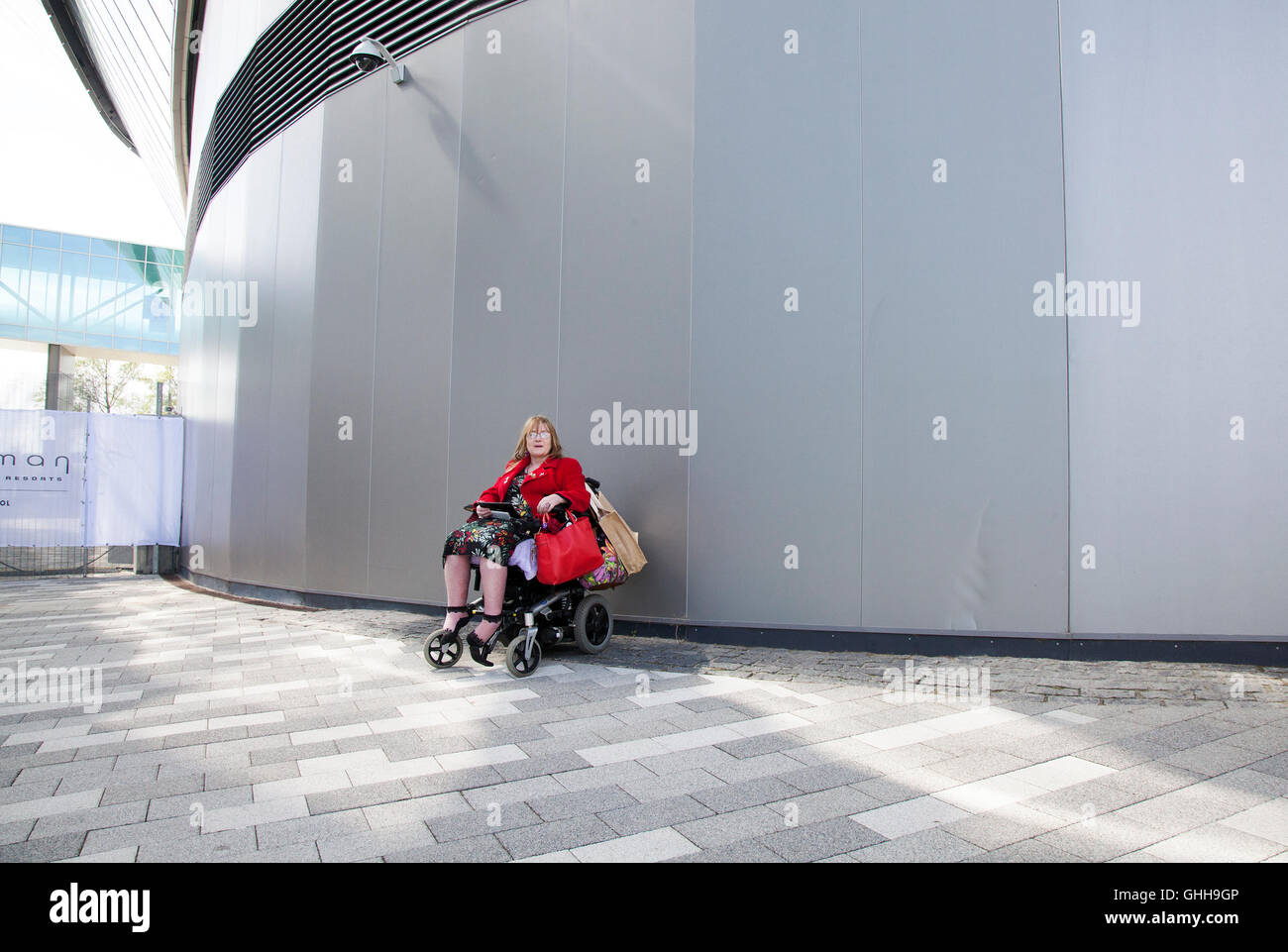 Liverpool, UK. 28th September, 2016.  Disabled Jacqueline Robinson cuts a lonley figure outside the entrance to the Labour Party conference in Liverpool.  Jacqueline, a paid up member of the Labour Party has been suspended excluded & banned from attending the conference.  She is a member of the Unite & Communications Workers Union and an activist for DPAC, 'Disabled People Against Cuts' and a lifelong Labour supporter. Credit:  Cernan Elias/Alamy Live News Stock Photo