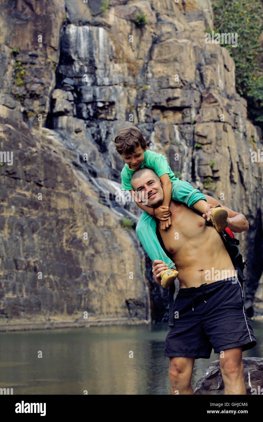 father and son making a trip to waterfall together, happy family on ...