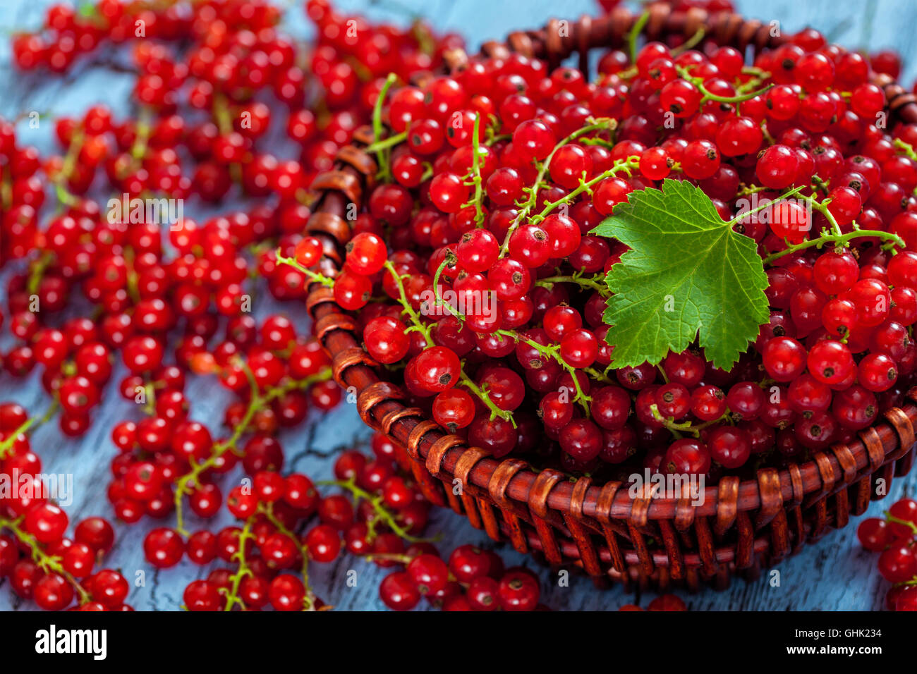 Redcurrant in wicker bowl on the table Stock Photo