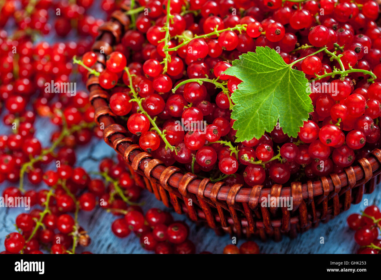 Redcurrant in wicker bowl on the table Stock Photo