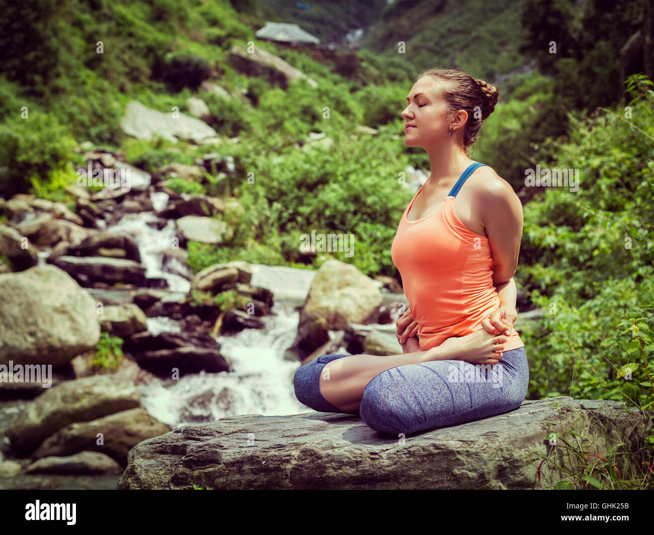 Young sporty fit woman doing yoga oudoors at tropical waterfall Stock ...