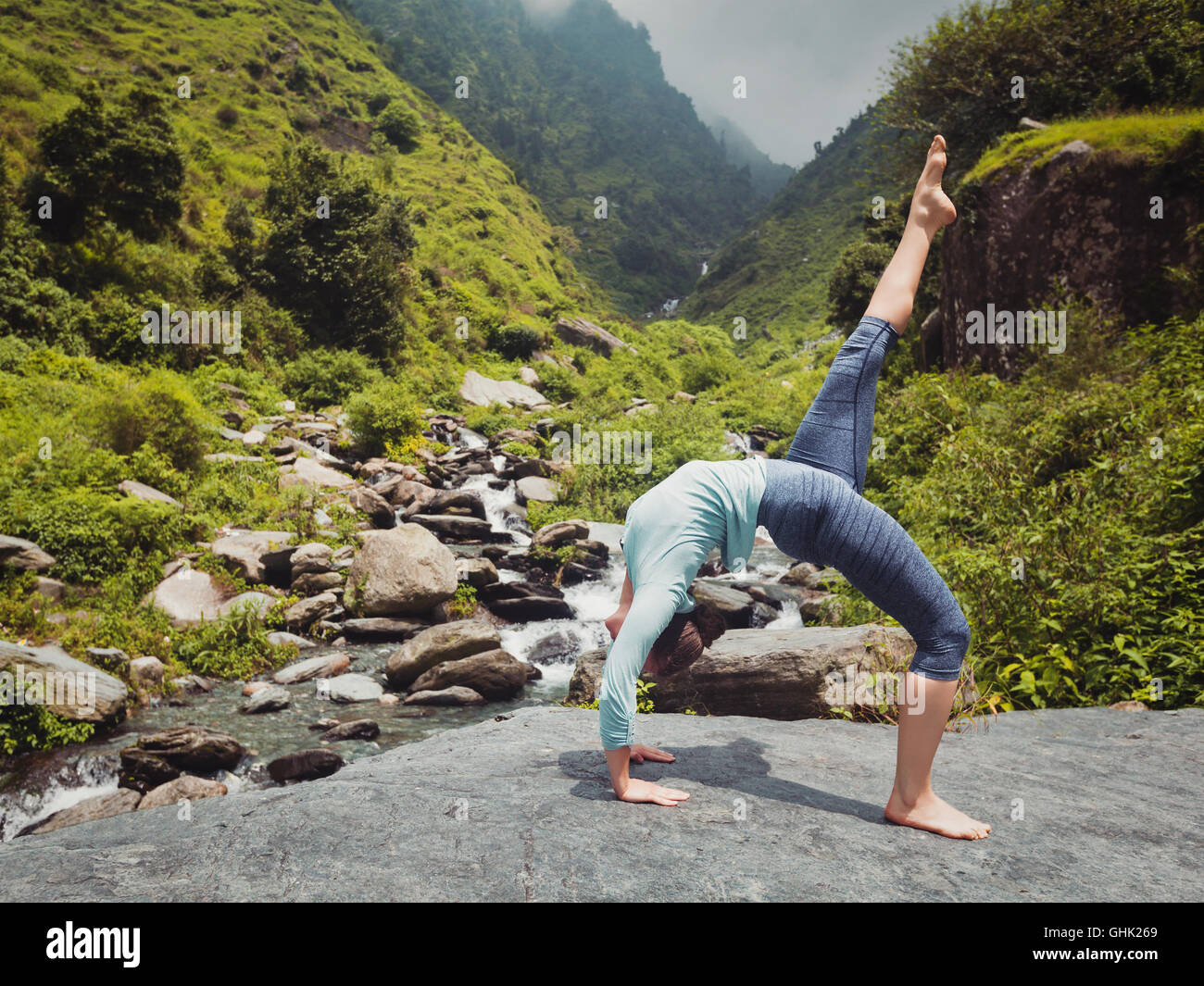 Woman doing yoga asana at waterfall Stock Photo - Alamy