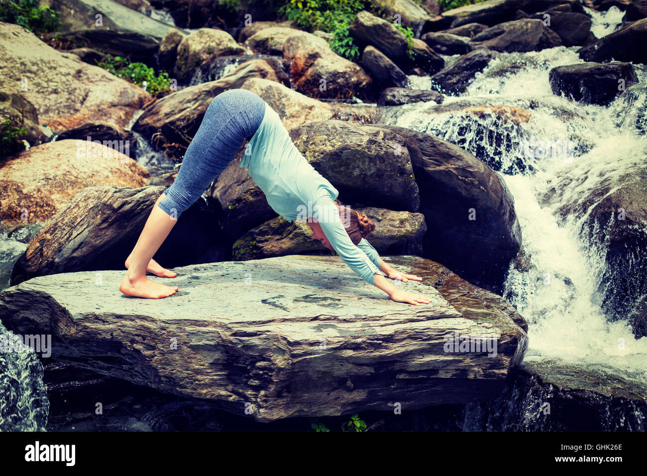 Young sporty fit woman doing yoga oudoors at tropical waterfall Stock ...