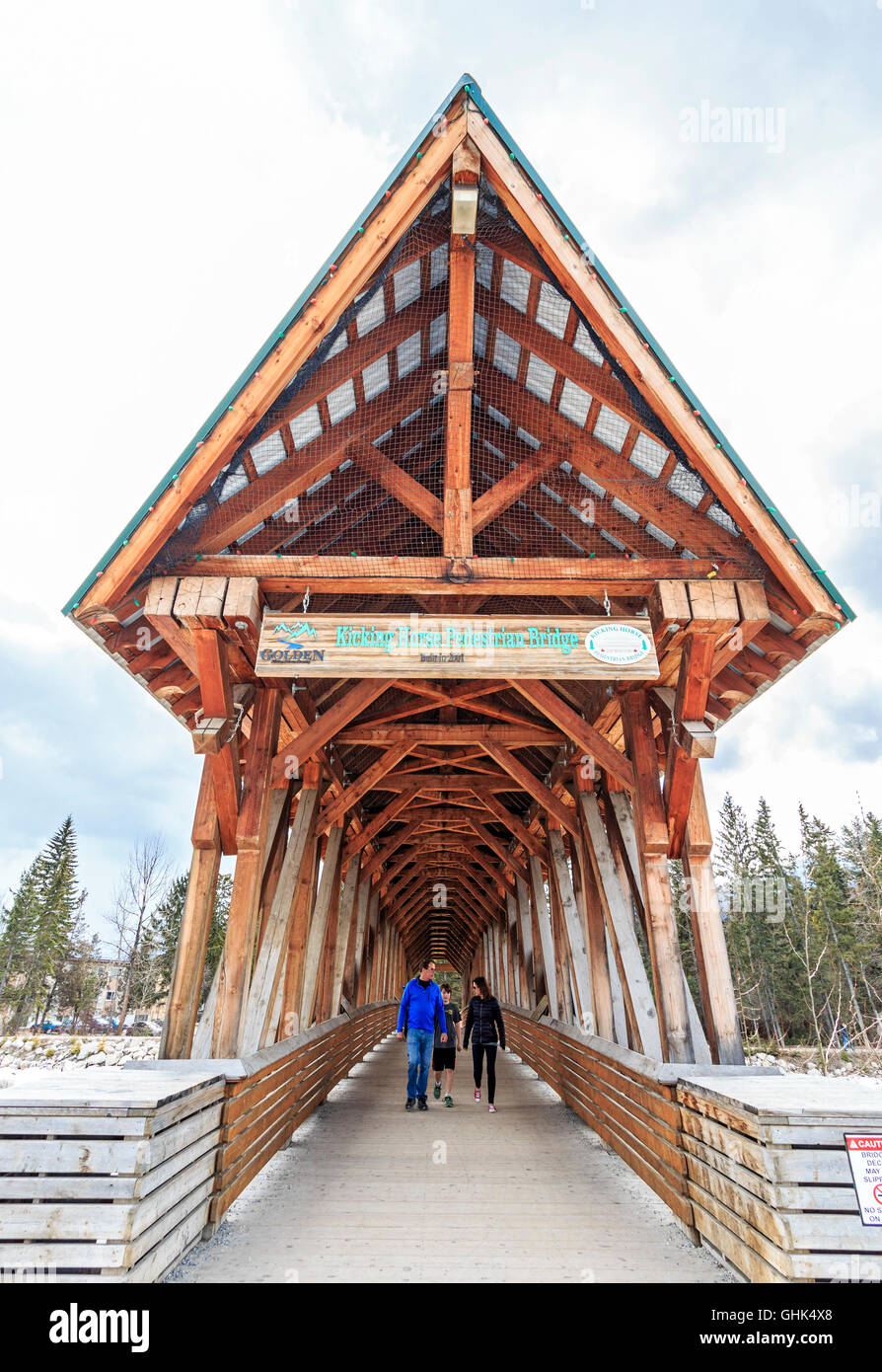 Family walks across Kicking Horse Pedestrian Bridge over the Kicking Horse River in the town of Kicking Horse, BC, Canada. Stock Photo