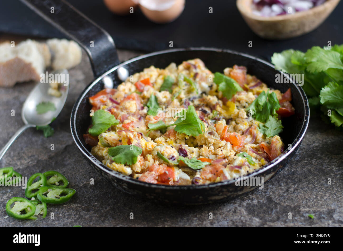 Indian scrambled eggs with tomatoes and chillies Stock Photo