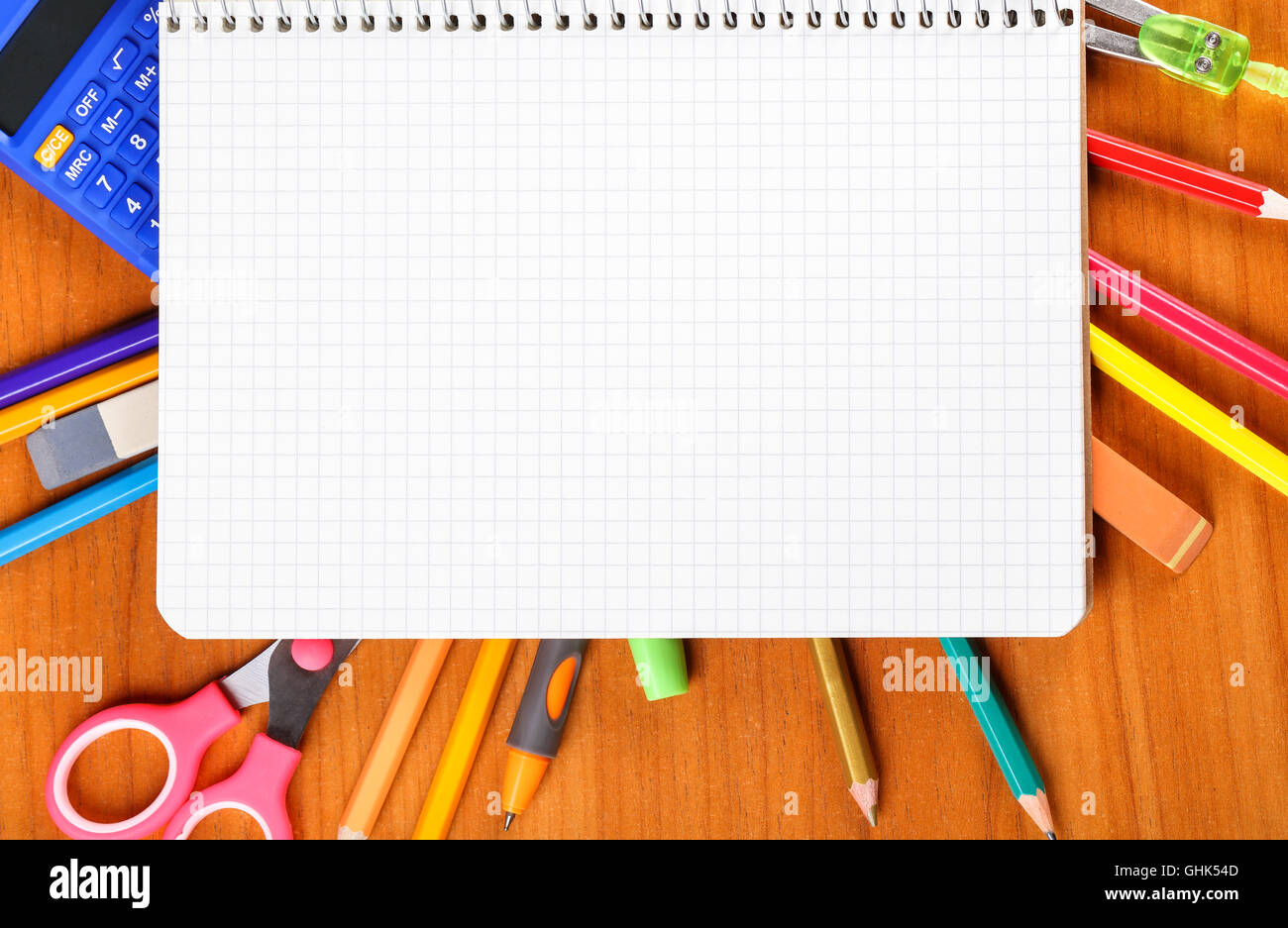 notebook, pencils, scissors, calculator, ruler, compass, pen on wooden
