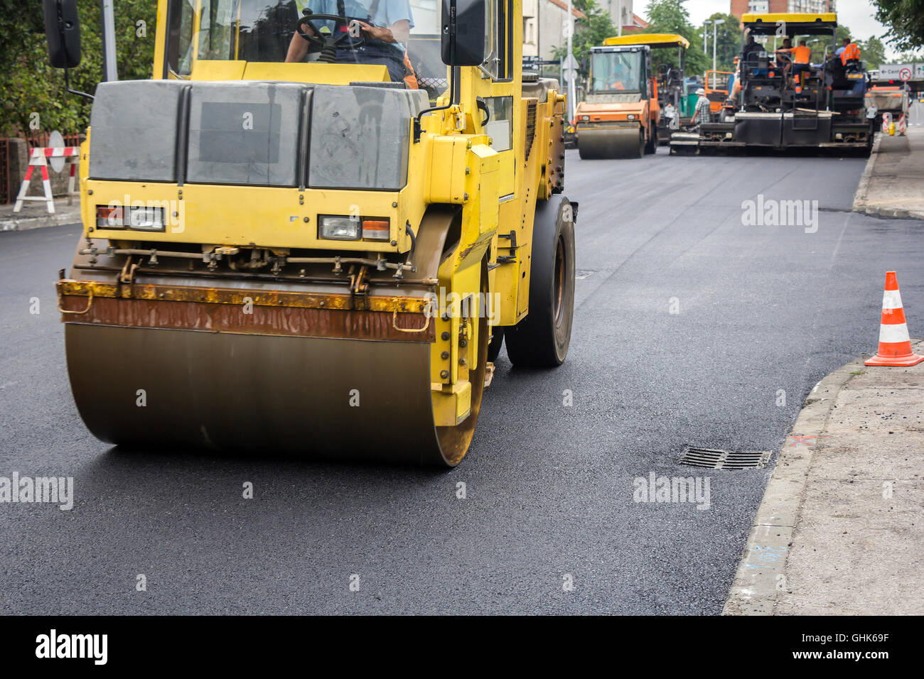 Compactor roller during road construction at asphalting work Stock Photo