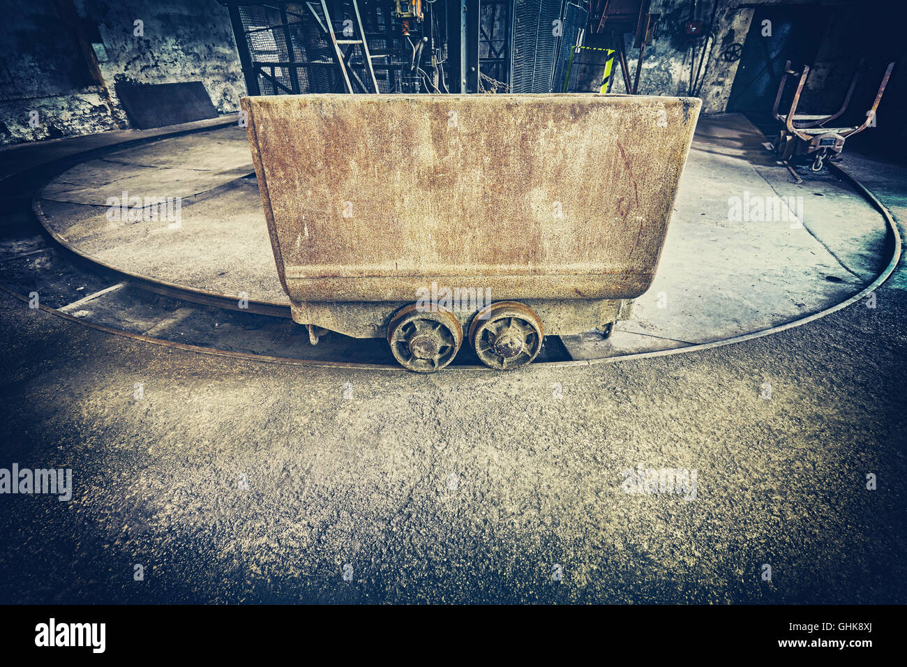 Retro toned old rusty mine cart, obsolete mining equipment. Stock Photo