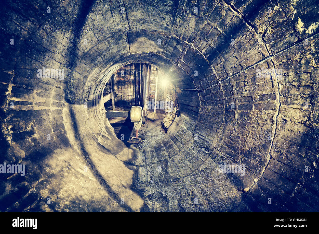 Retro toned old abandoned coal mine ventilation tunnel, industrial grunge background. Stock Photo