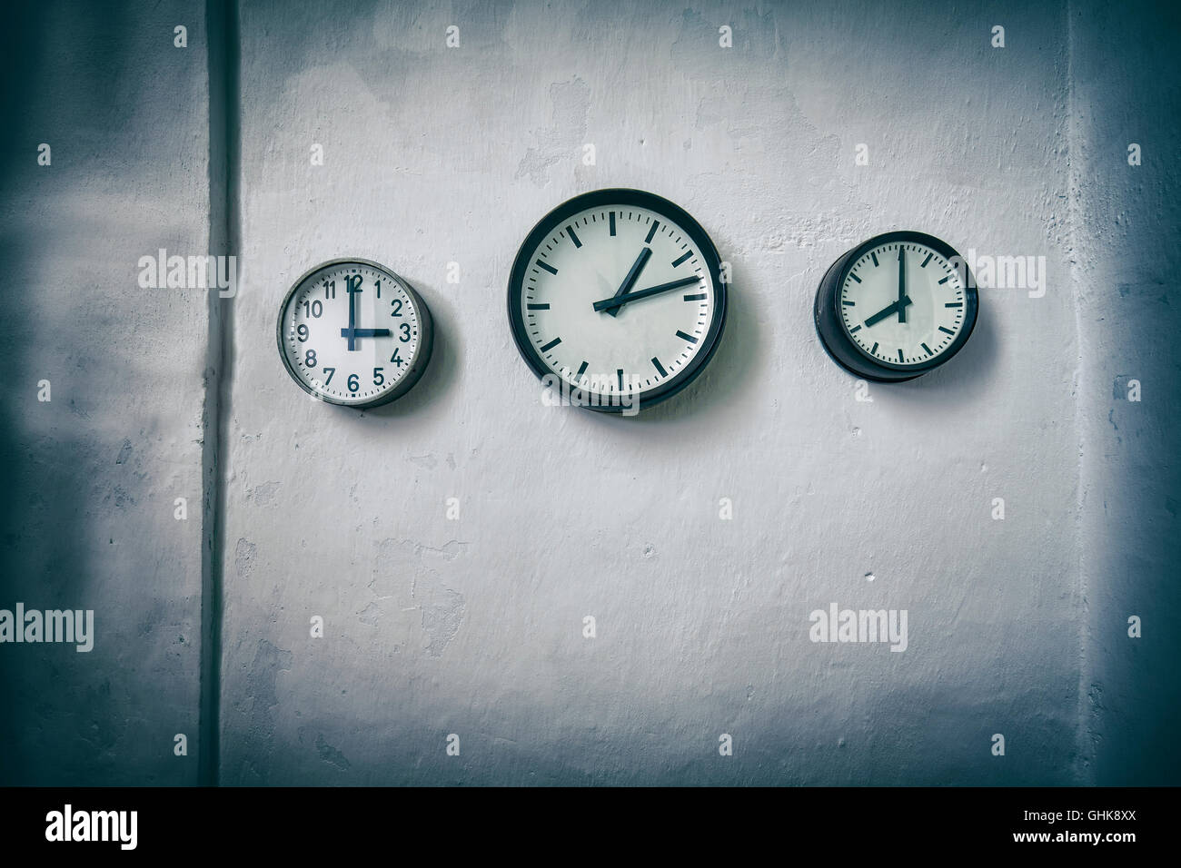 Vintage toned clocks on a grunge wall, time passing concept, space for text with effect