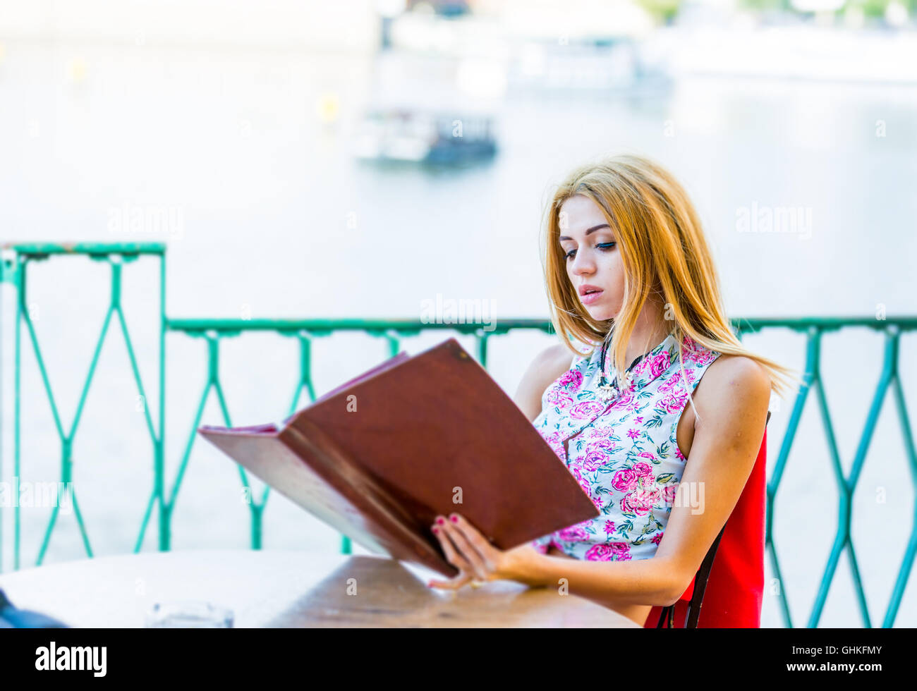 Beautiful Young Woman reading Menu in street cafe Stock Photo