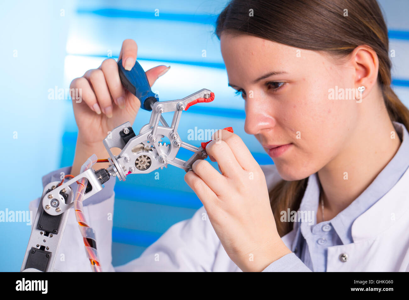Young woman technician repair roboter manipulator Stock Photo
