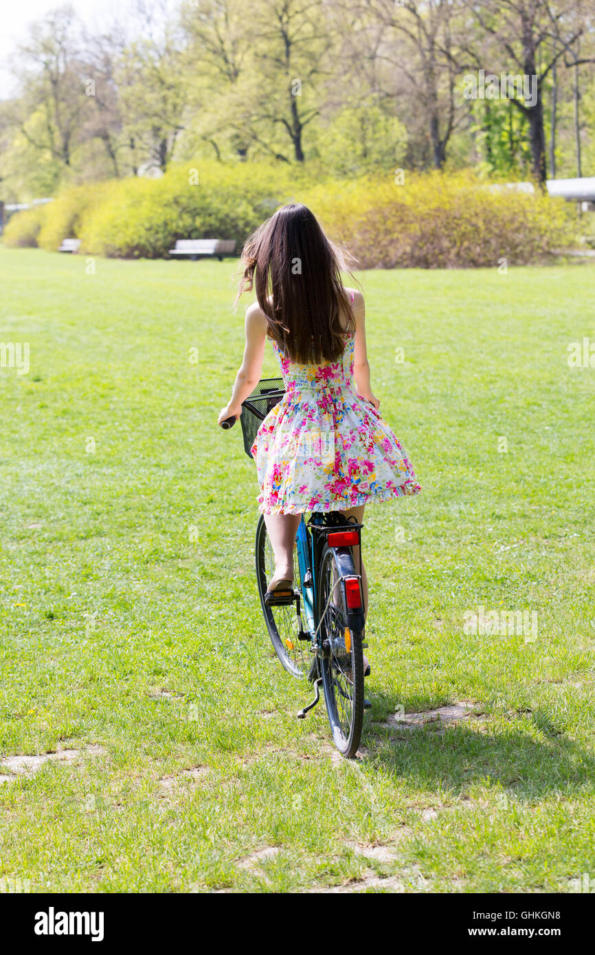 Young woman riding bike in spring park Stock Photo