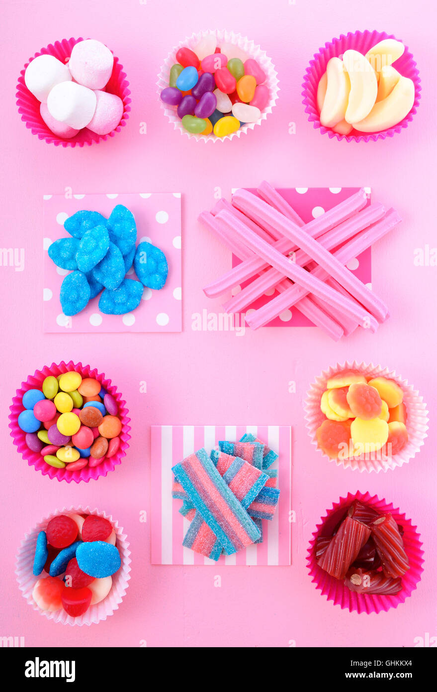 Bright colorful candy background on pink wood table for Halloween trick of treat or childrens birthday party favors. Stock Photo