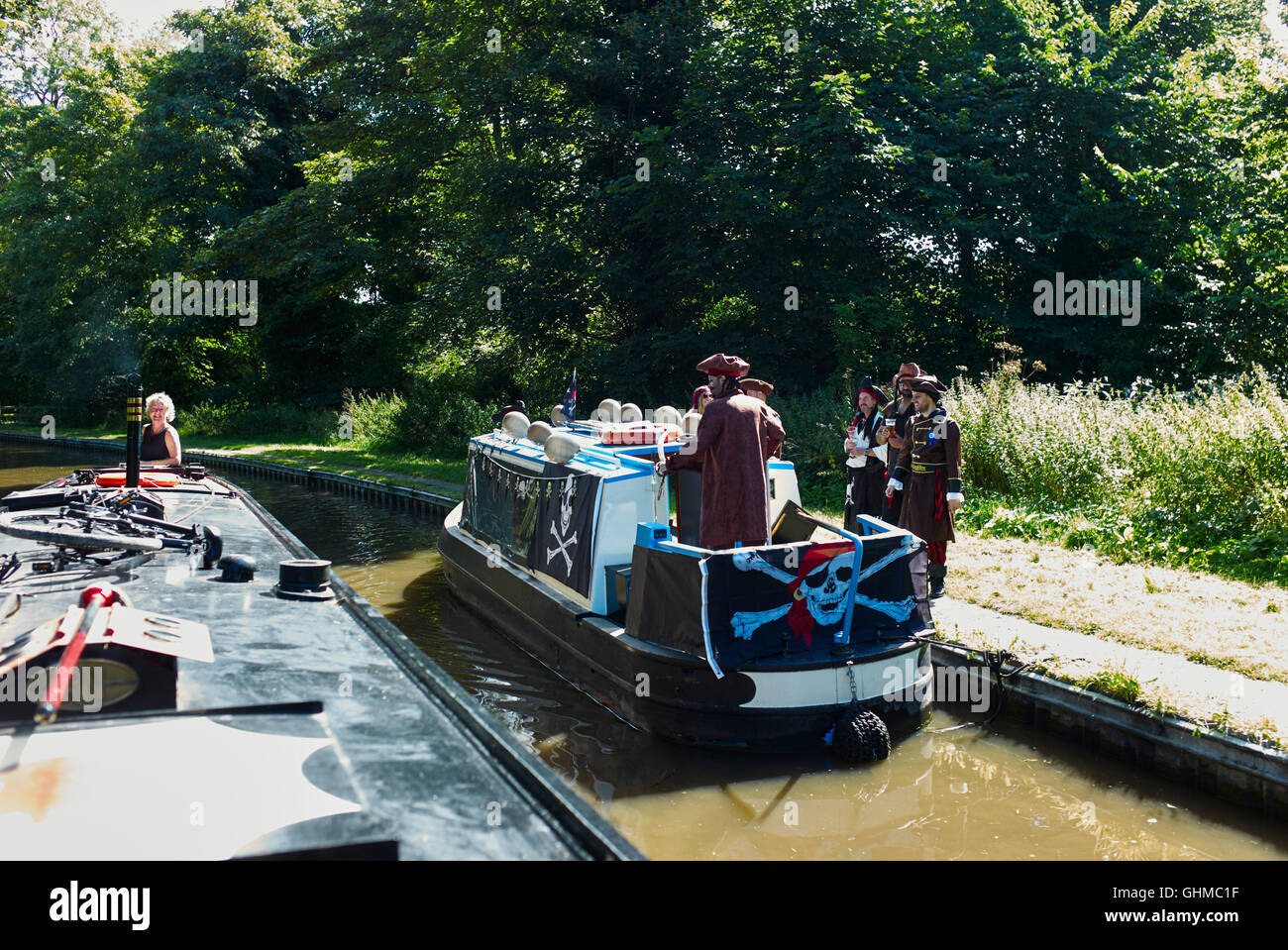 Narrowboat William passes a band of pirates in a hired dayboat on the Trent and Mersey Stock Photo