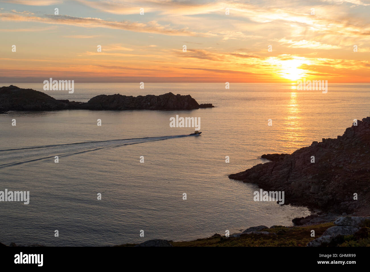 Sunset between Shipman Head, Bryher and Tresco, Isles of Scilly Cornwall England UK.  Tresco Boat Services jetboat rib passing between the islands. Stock Photo