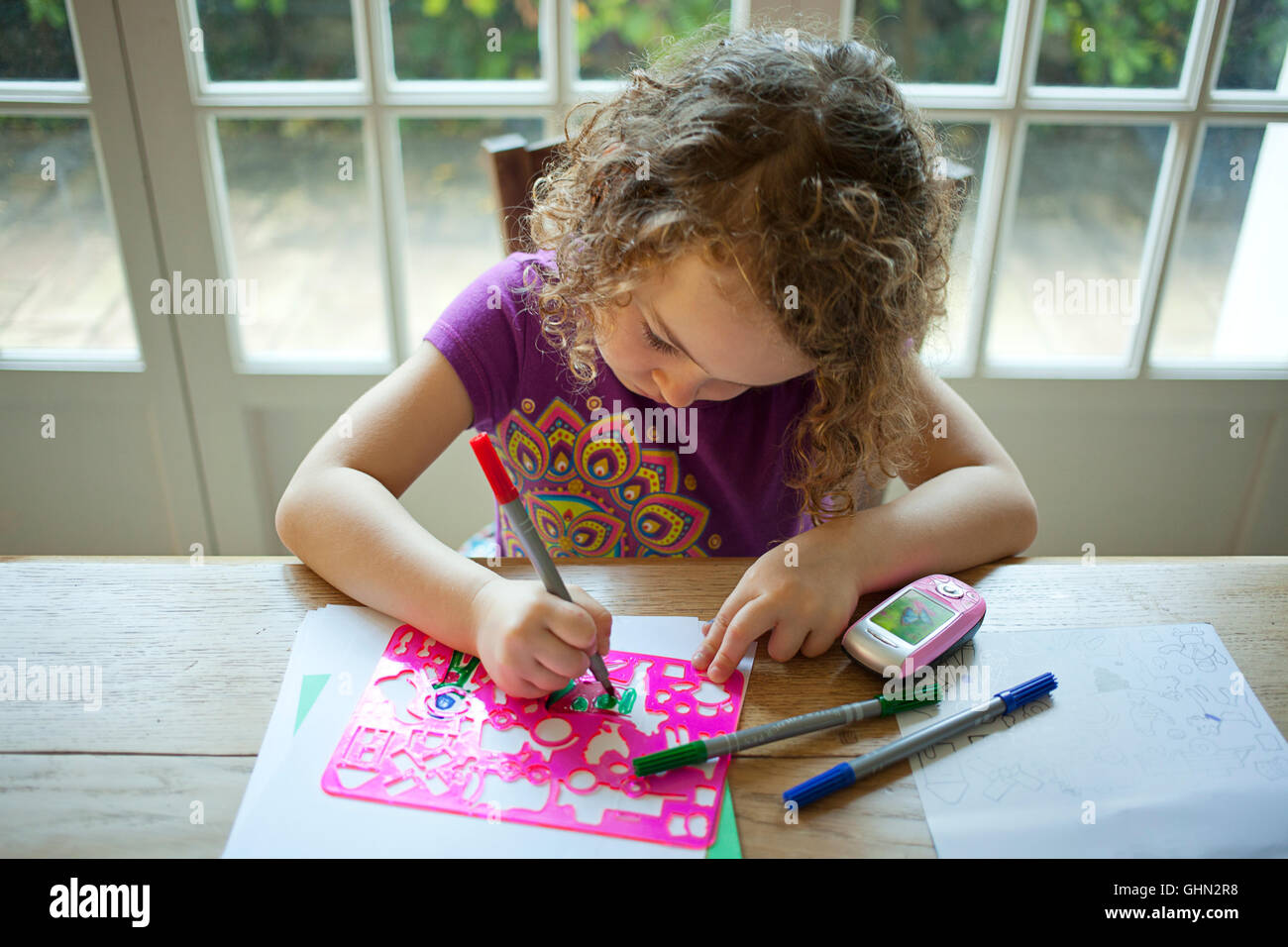 Young girl colouring in at a desk Stock Photo