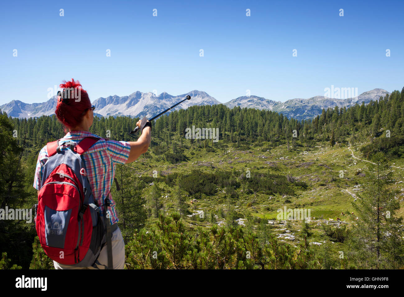 Woman hiker shows the mountain peak Stock Photo - Alamy