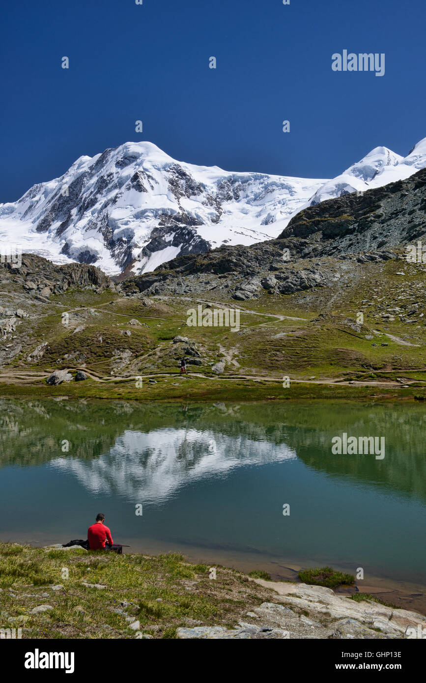 Hiker enjoying alpine solitude at the Riffelsee Lake, Zermatt, Switzerland Stock Photo