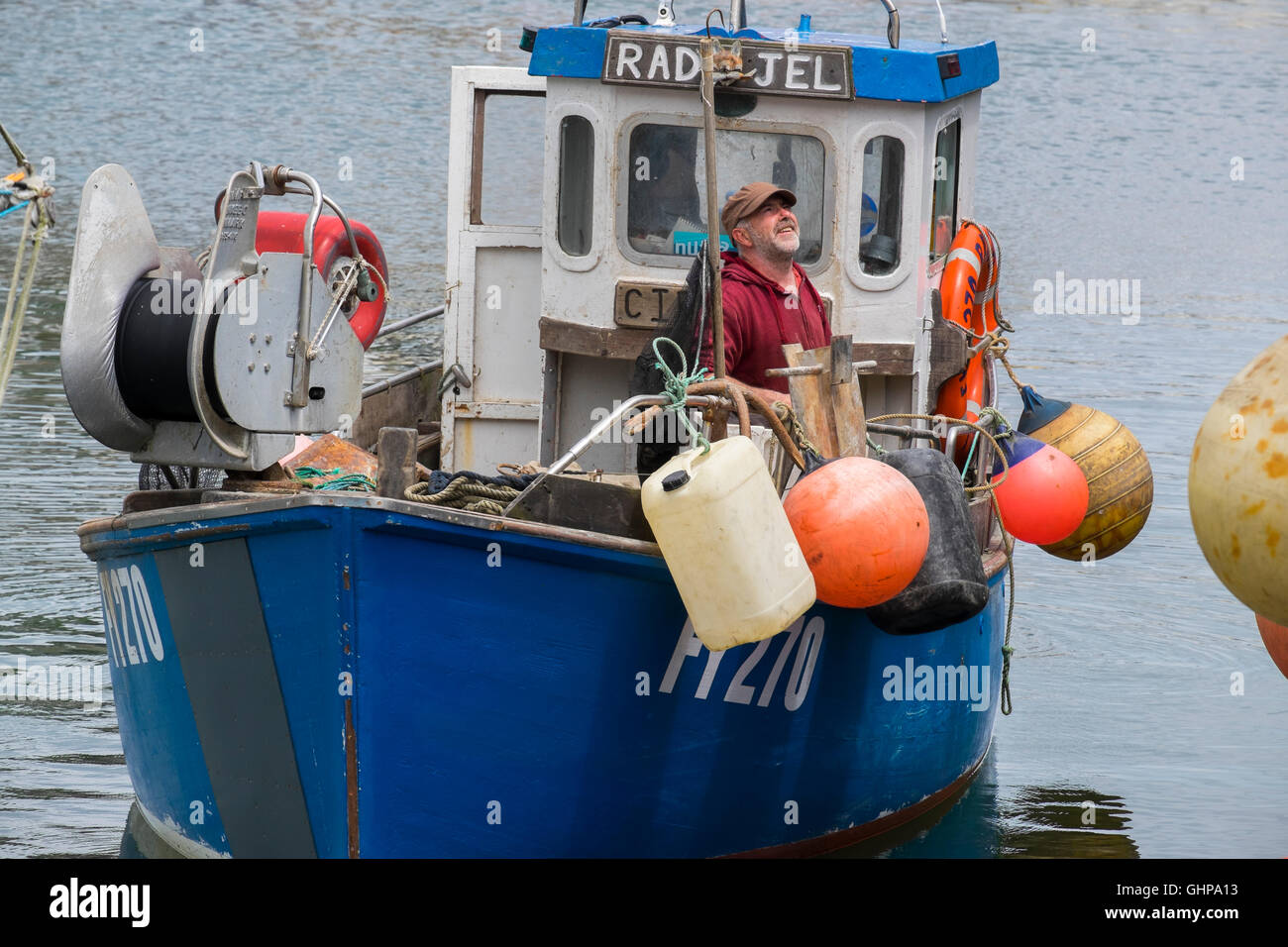 A fisherman and boat in Mevagissey Harbour, Cornwall, England, UK Stock Photo