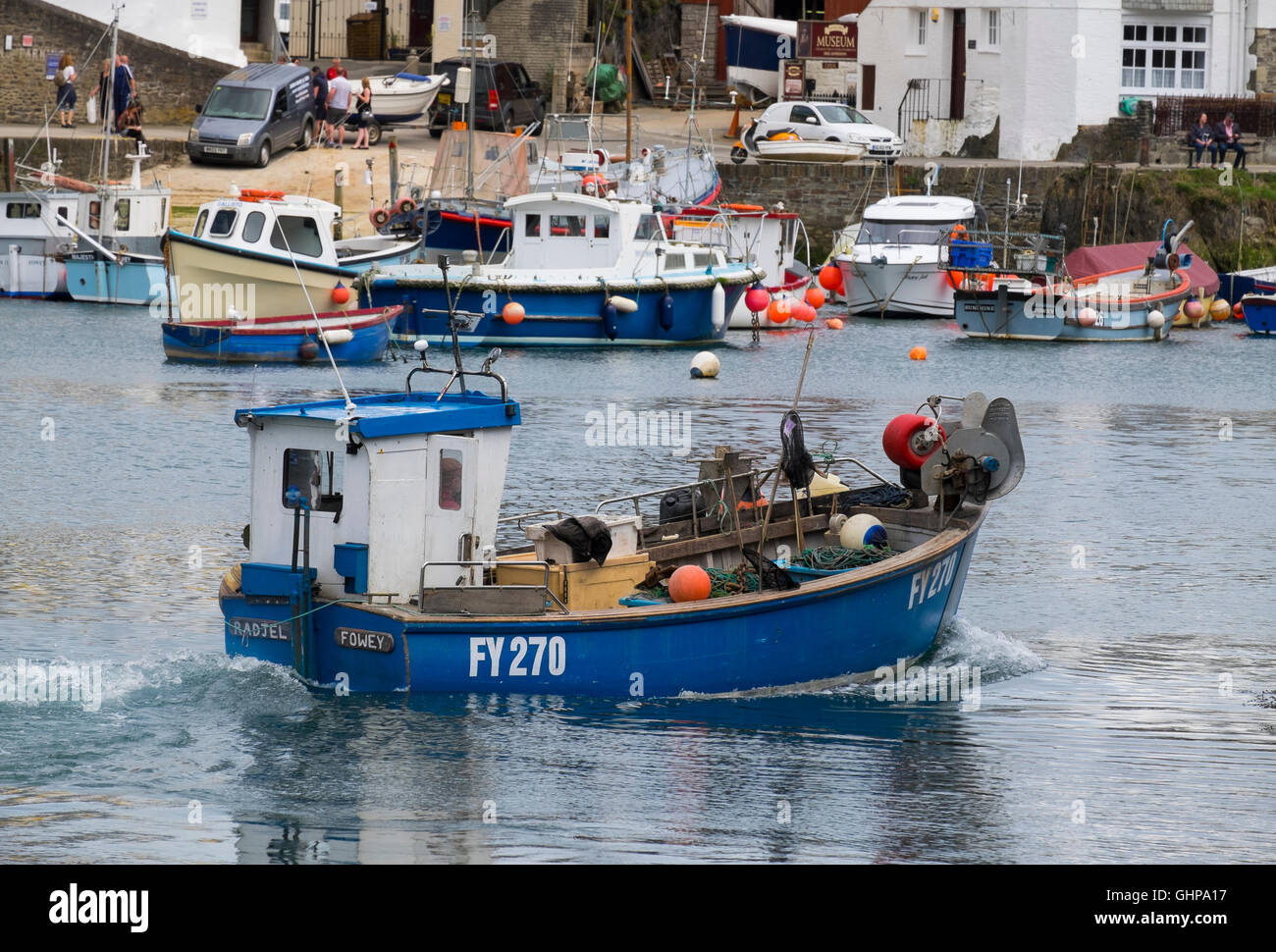 A fishing boat makes its way out of Mevagissey harbour, Cornwall, England, UK Stock Photo