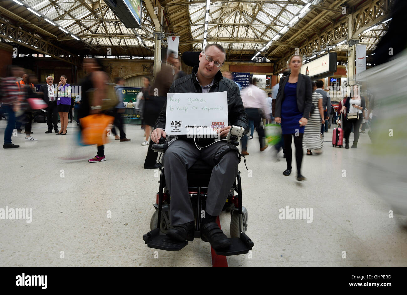 A protester holds a sign during a rail strike demonstration at London Victoria Station against the Southern Rail network, calling for a fare freeze and compensation. Stock Photo