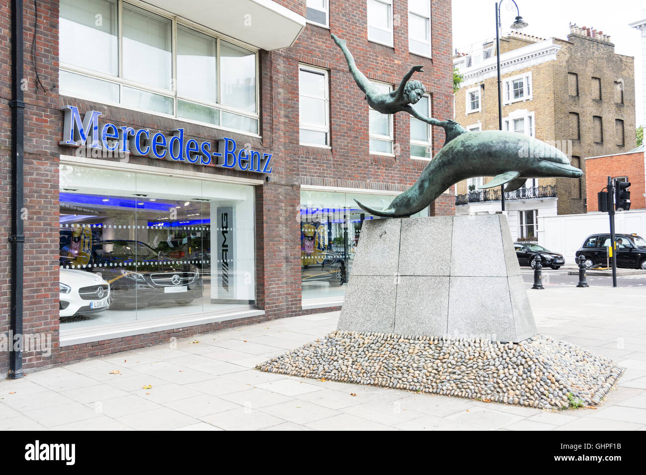 London, England, UK: Boy with a Dolphin by David Wynne outside the Mercedes-Benz showroom, Chelsea, London, UK Stock Photo