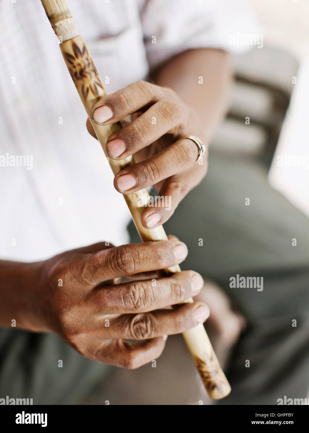 Wind instrument maker Yim Seychot plays a Cambodian flute at his home outside Phnom Penh, Cambodia. Stock Photo