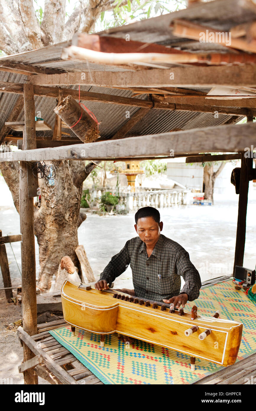 Teacher Teav Nop plays Cambodian wedding music on a Takhe. Chambok Village, Bati District Takeo Province. Cambodia Stock Photo