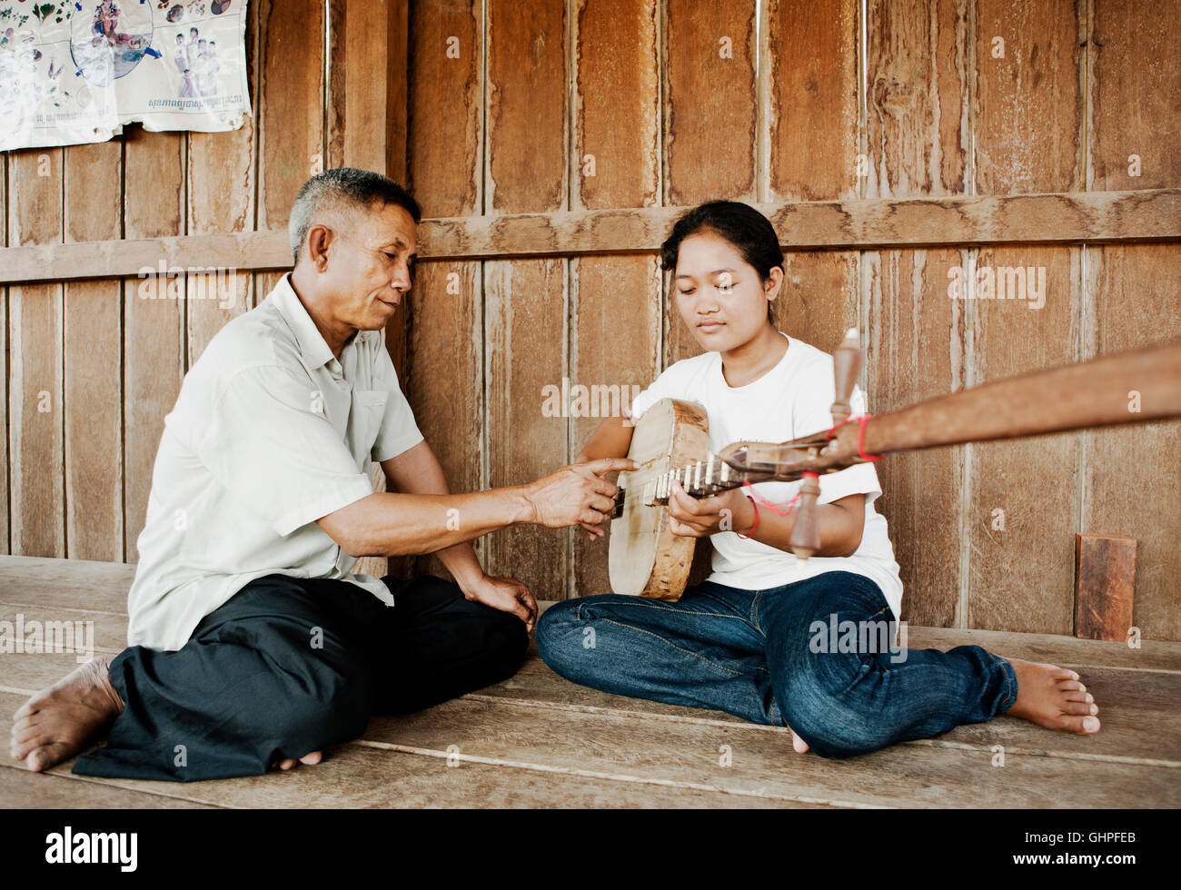 Master musician Man Men teaches a student .classical wedding music on her Chapei Dang Weng. A Cambodian long-necked lute...Man M Stock Photo