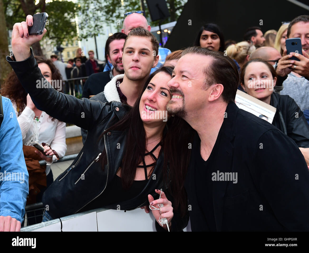 Ricky Gervais takes selfies with fans attending the world premiere of