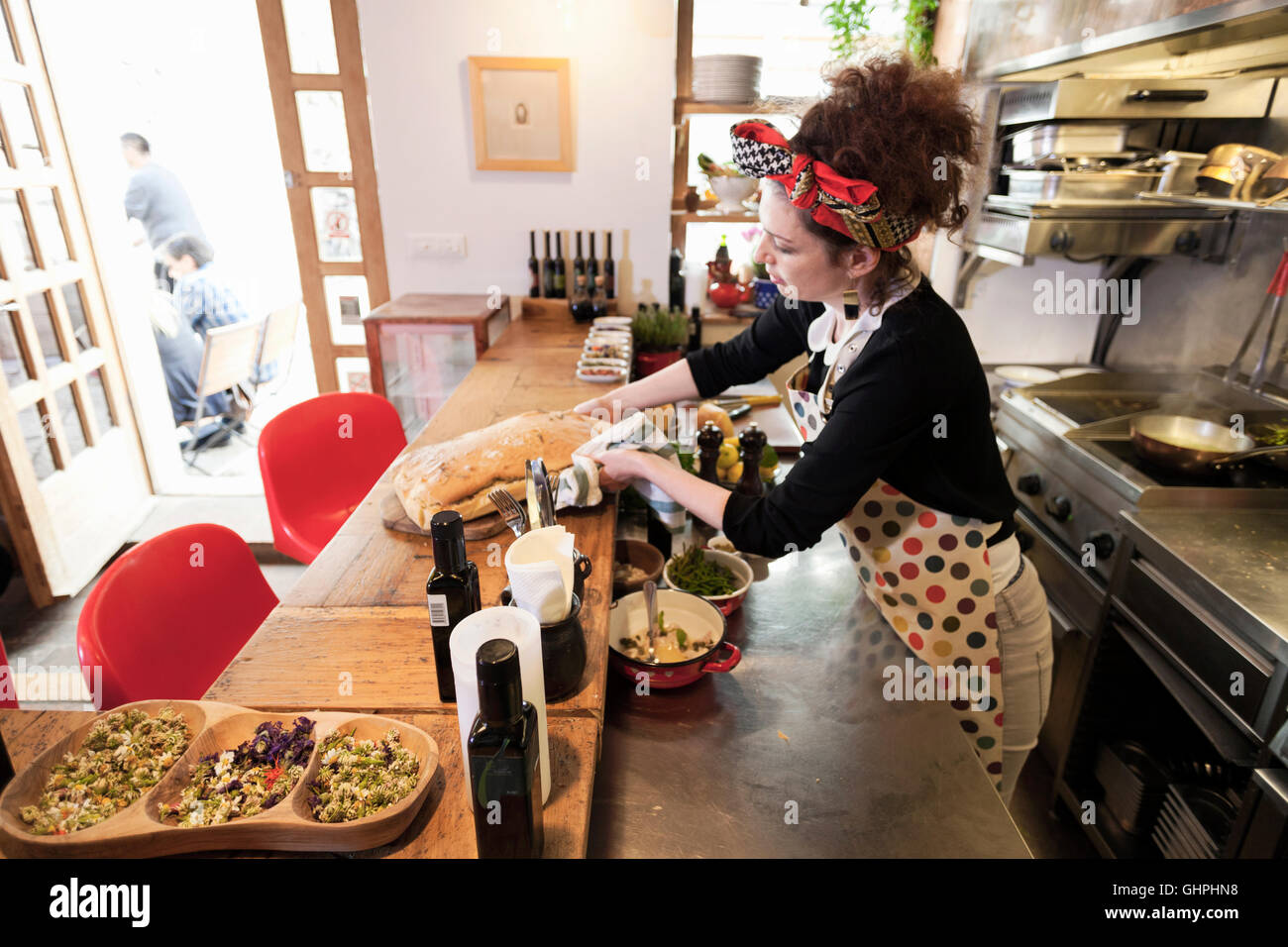 Female cook putting fresh food on bar counter Stock Photo