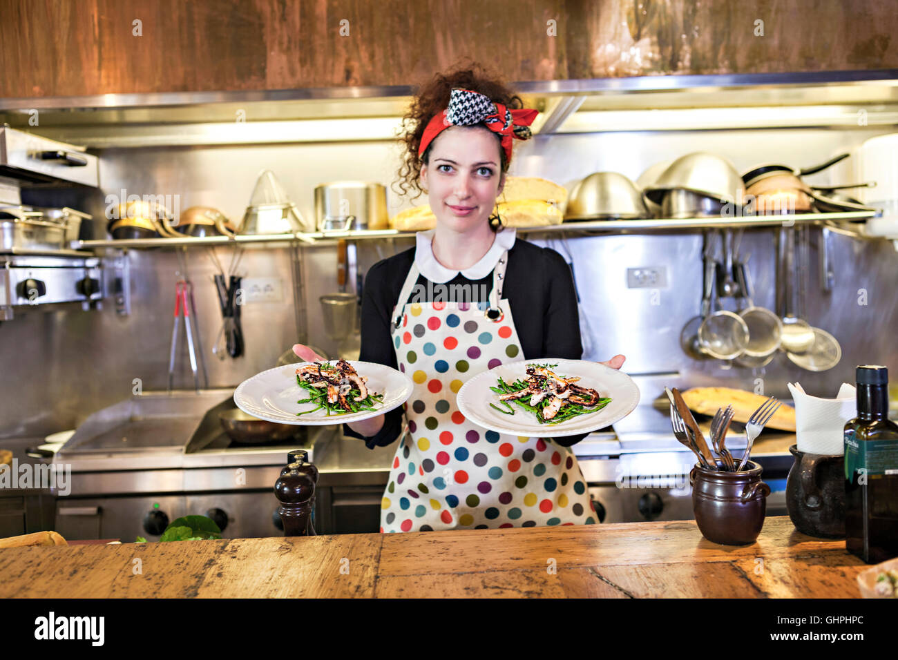 Female chef in restaurant serving fresh calamari dish Stock Photo