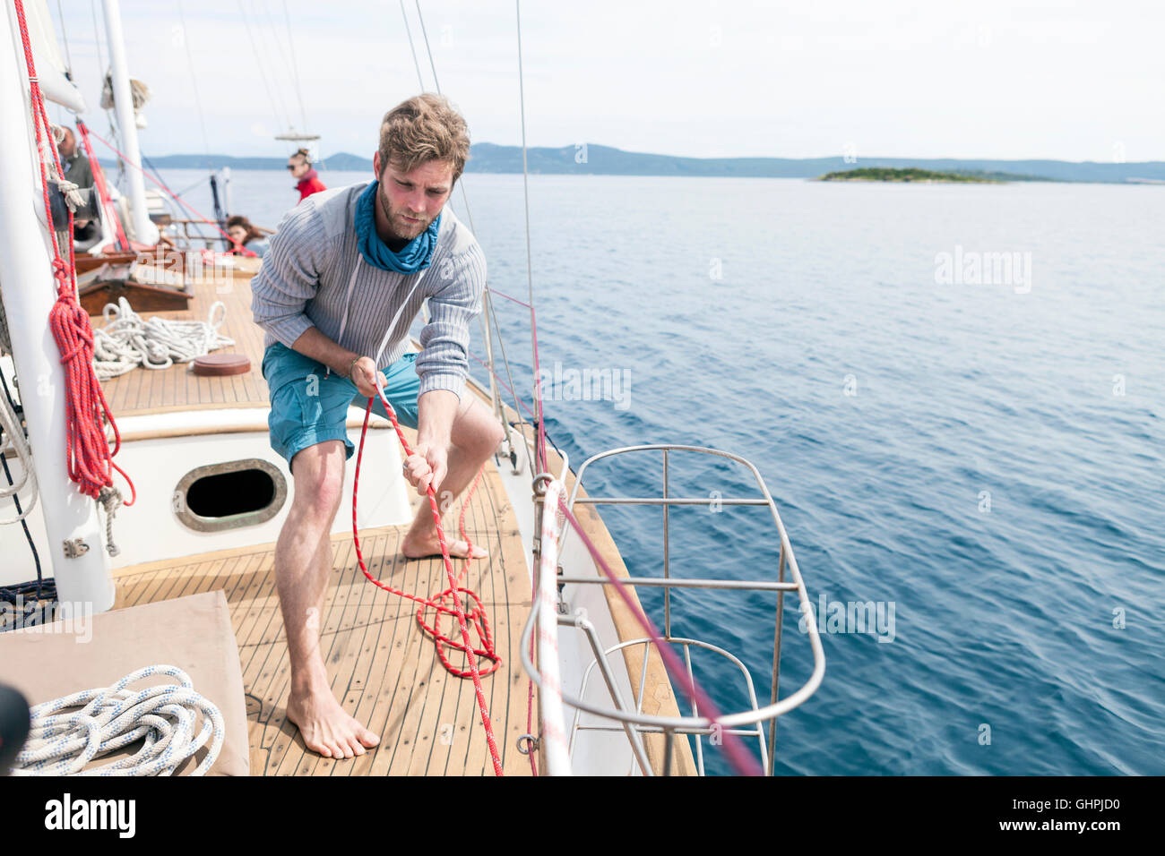 Man pulling on rope on yacht Stock Photo