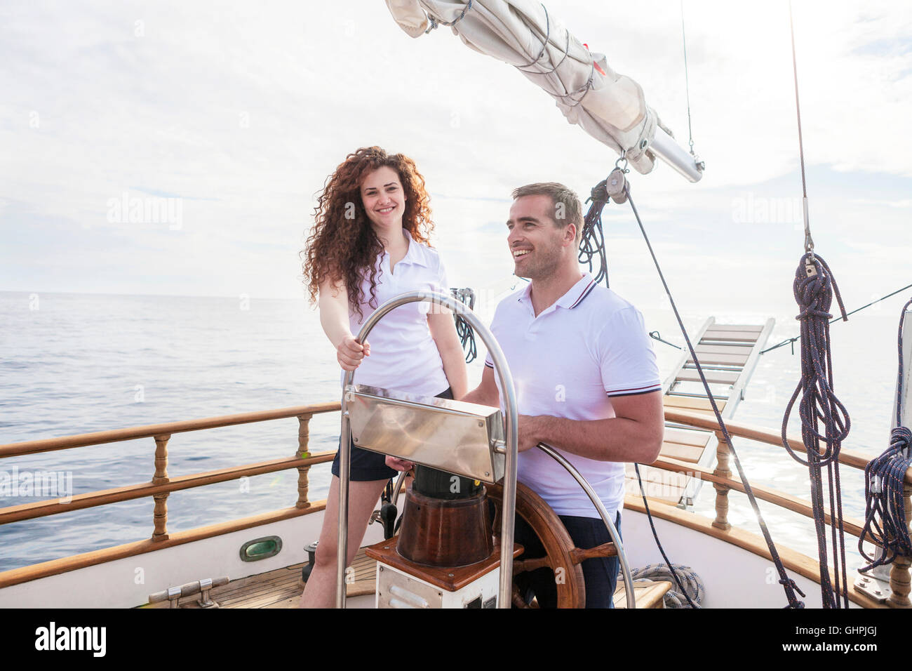 Young couple steering sailboat together Stock Photo