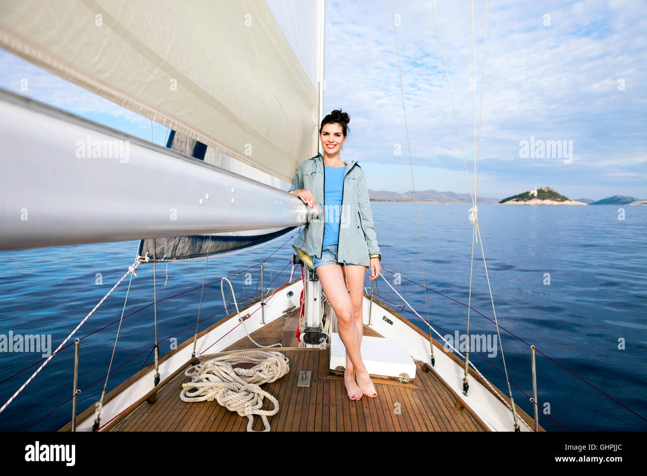 Young woman leaning on sailboat sail Stock Photo