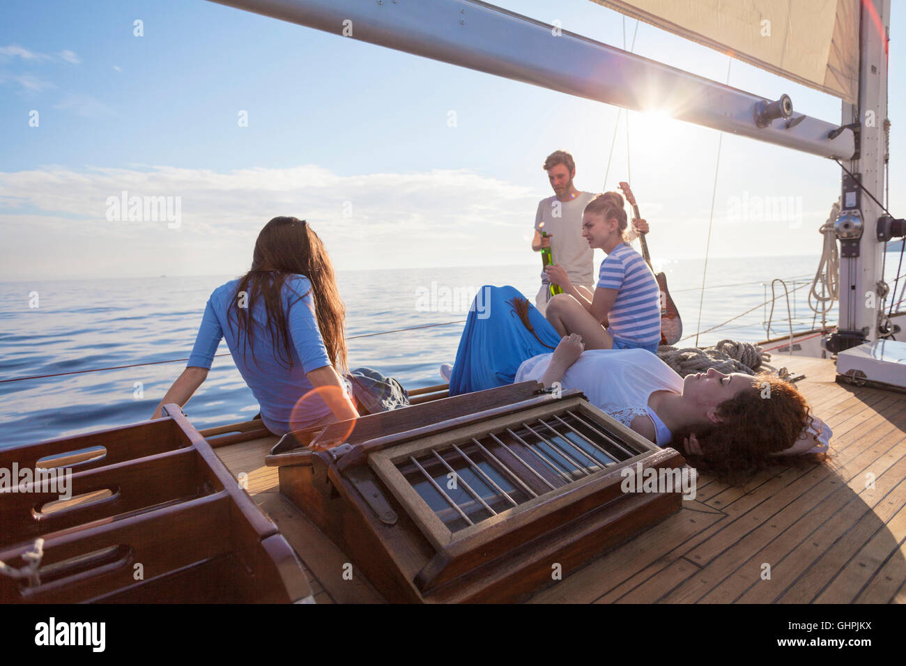 Friends relaxing on boat deck of sailboat Stock Photo