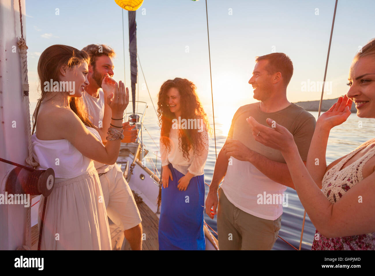 Friends celebrating and laughing on sailboat Stock Photo