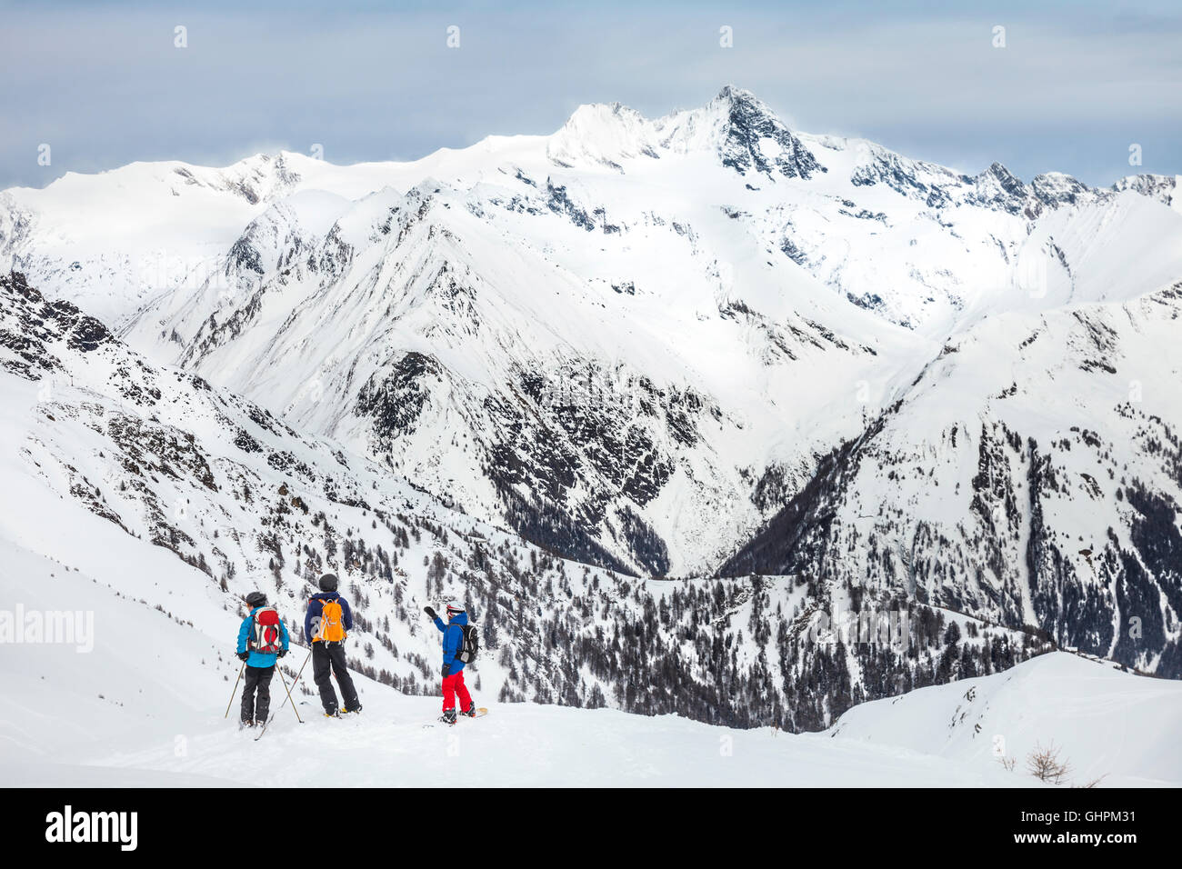 Freeskier in front of the Großglockner, the highest mountain in Austria. Eine Gruppe von Skifahrern und Snowboardern schauen in  Stock Photo