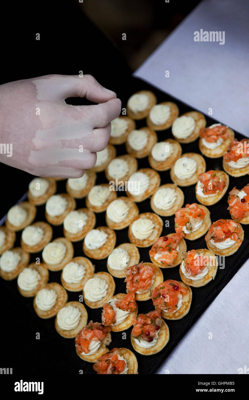 Chef cooking blini with smoked salmon and herbs cream Stock Photo