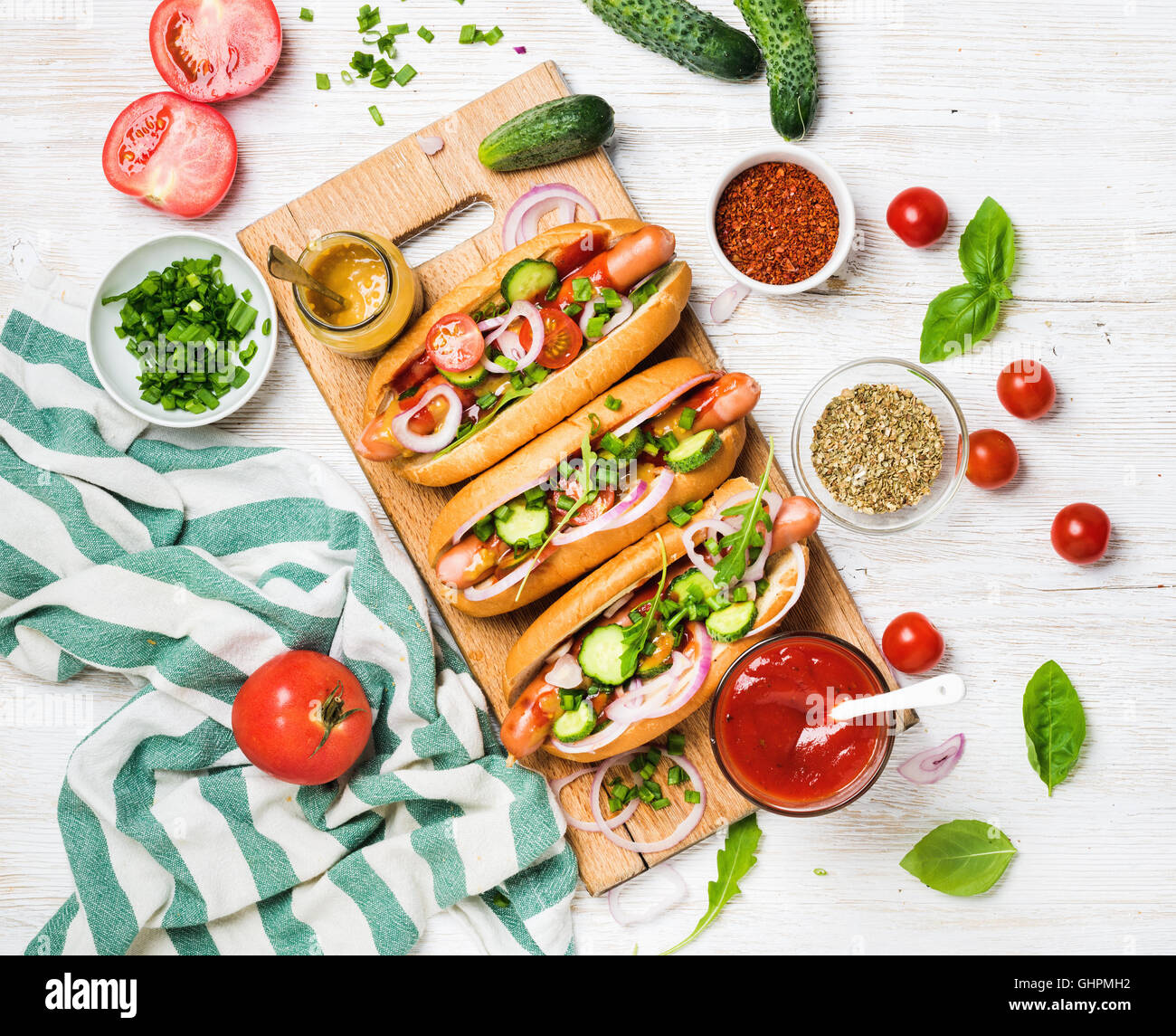 Homemade hotdogs with fresh vegetables, spices, ketchup and mustard
