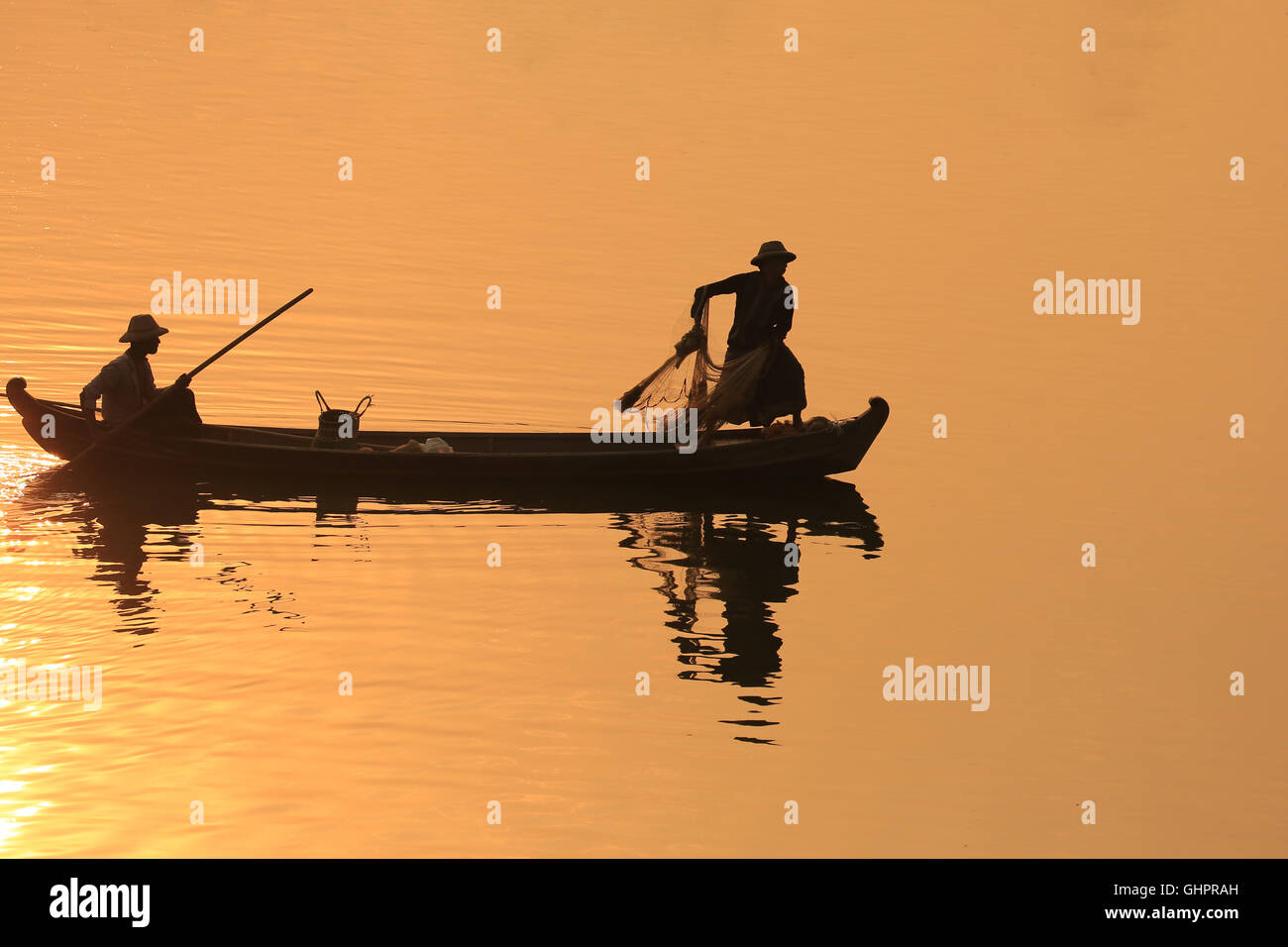 Asia, Two Fisherman silhouette on the boat catch fish the sunrise time ...
