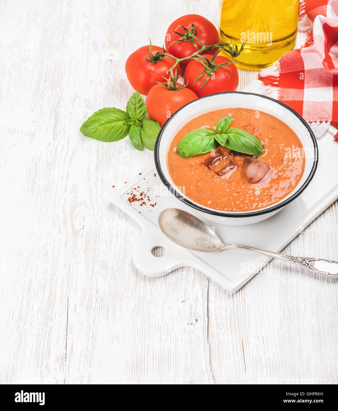 Cold gazpacho soup with ice, fresh basil and red tomatoes Stock Photo