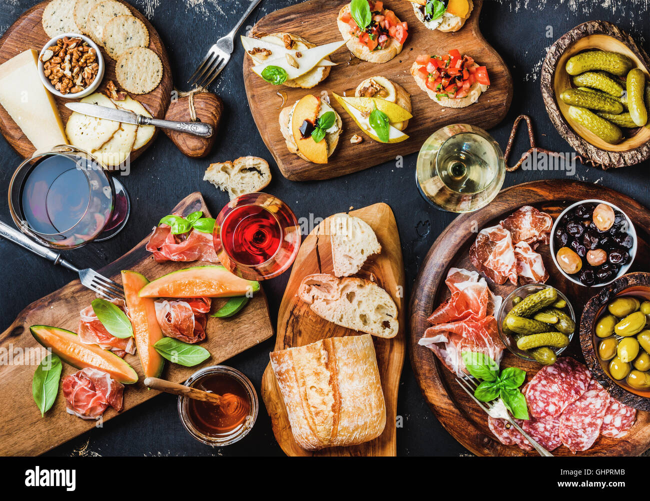 Italian antipasti wine snacks set over black grunge background Stock