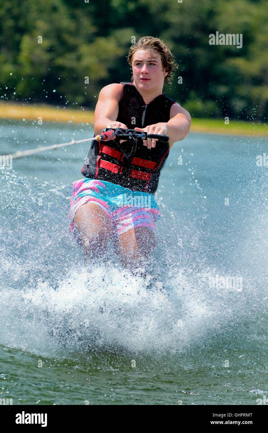 Close up of a teen boy trick skiing, he has just been pulled up. Stock Photo