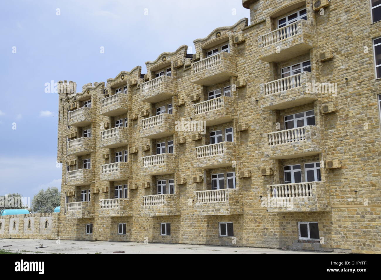 The hotel building, covered with decorative stone. Multi-storey hotel with a decorative trim, which is called Dagestani stone. Stock Photo