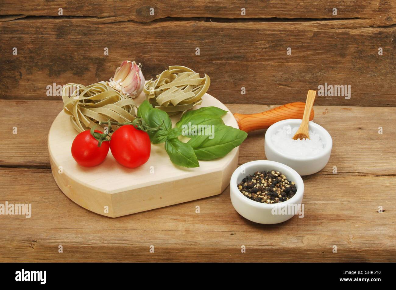 Tagliatelle and ingredients on a background of weathered wood Stock Photo