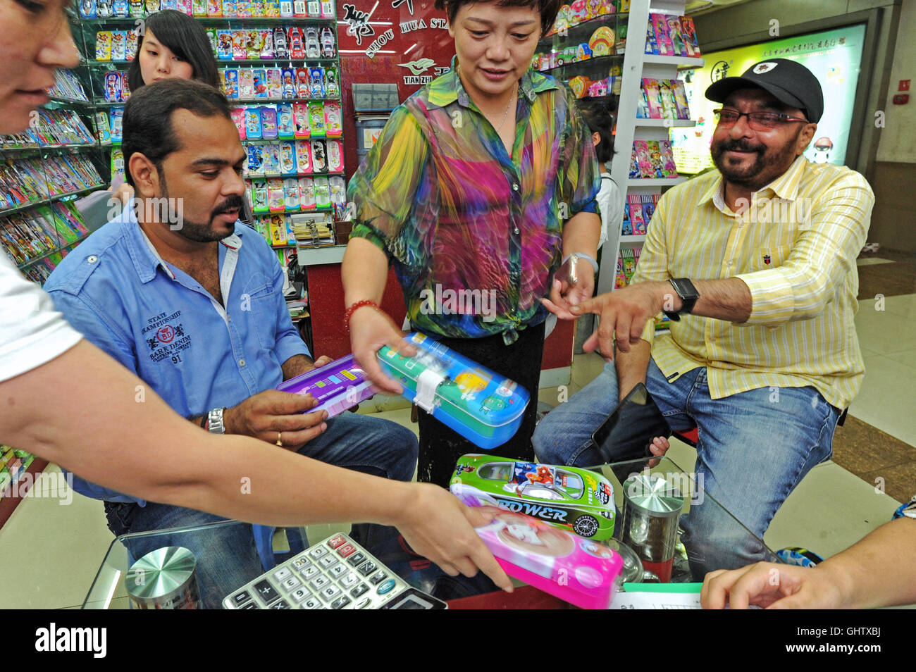 (160811) -- YIWU, Aug. 11, 2016 (Xinhua) -- Indian trader Jatinder Sayal (1st R) talks business with Chinese dealers in Yiwu, a famous production base for small commodities in east China's Zhejiang Province, Aug. 3, 2016. Jatinder Sayal came to Yiwu to do business of commodity export in 2008 and opened a company in 2010. His company's sales revenue reached 16 million yuan (2.4 million US dollars) in 2015. There are more than 13,000 resident foreign traders from over 100 countries and regions in Yiwu, according to statistics. (Xinhua/Tan Jin) (wyo) Stock Photo